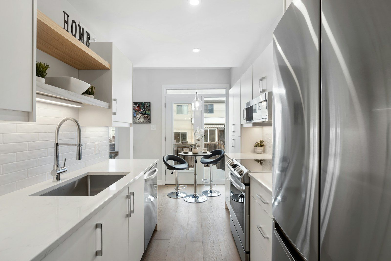 Cucina moderna con ante bianche ed elettrodomestici in acciaio inox