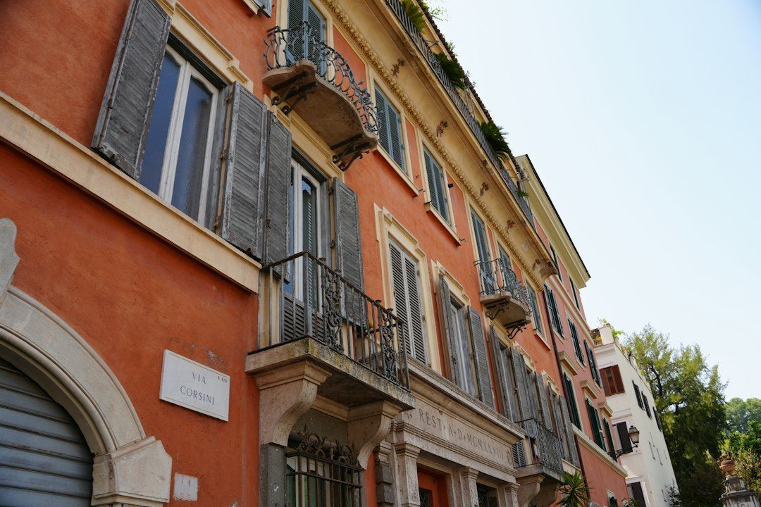 Facciata di un edificio storico con persiane chiuse e balconi in ferro battuto